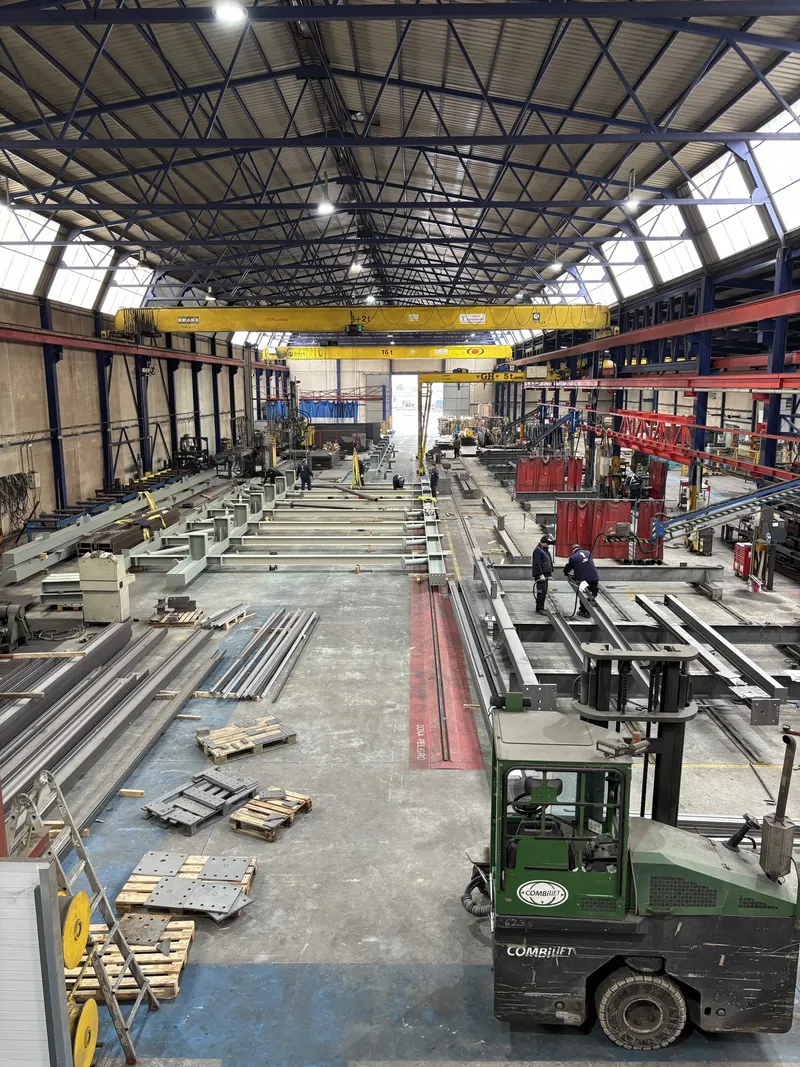 Interior de la nave de Luvimetal con puentes grúa, perfiles acopiados y carretilla elevadora